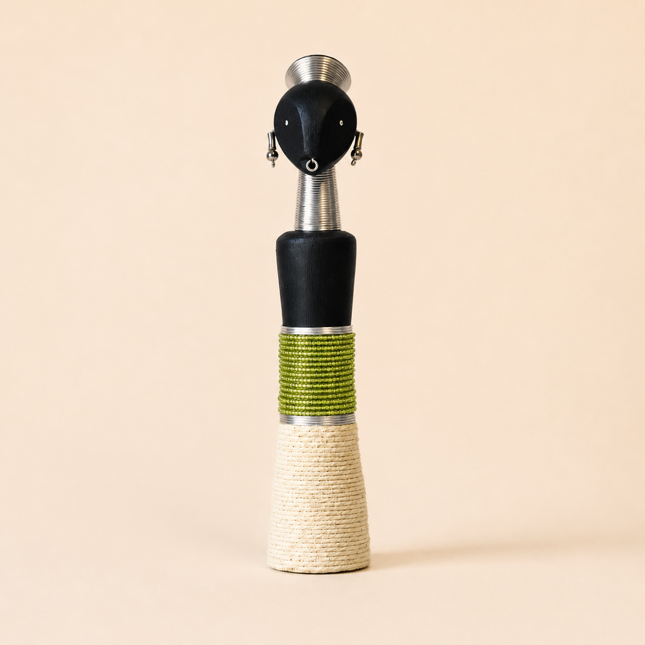 African carved doll with a green and beige design on a beige background