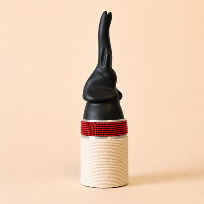 Black and red woven design on a carved elephant with a beige background