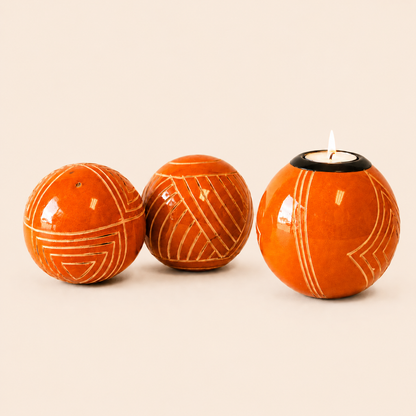Carved and coloured Monkey Balls and Tlite in orange and set on a beige background