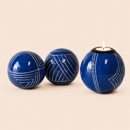Carved and coloured Monkey Balls and Tlite in blue and set on a beige background