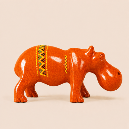 Orange hippo figurine with decorative patterns on a beige background