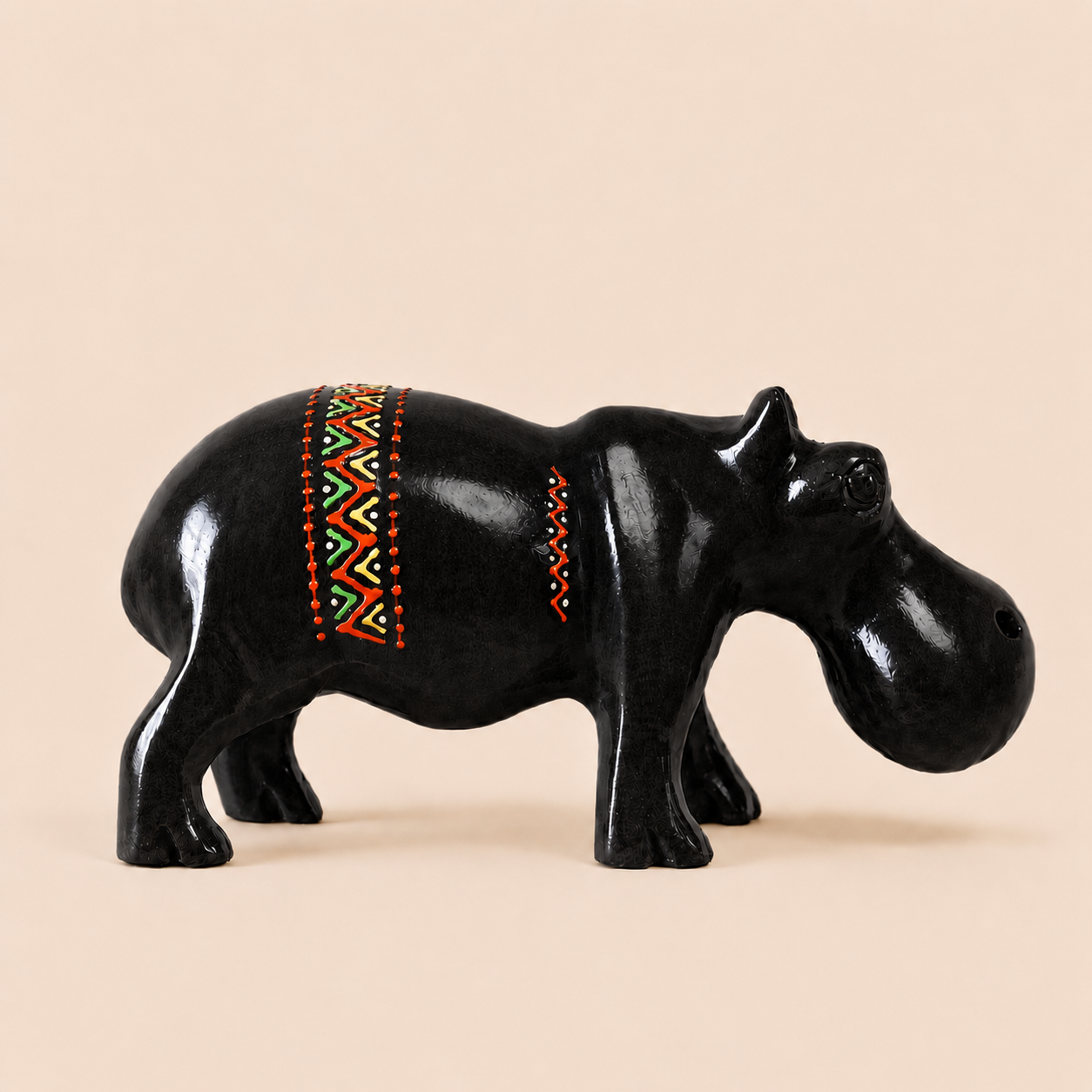 Black hippo figurine with colorful pattern on a beige background