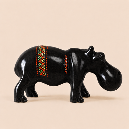 Black hippo figurine with colorful pattern on a beige background
