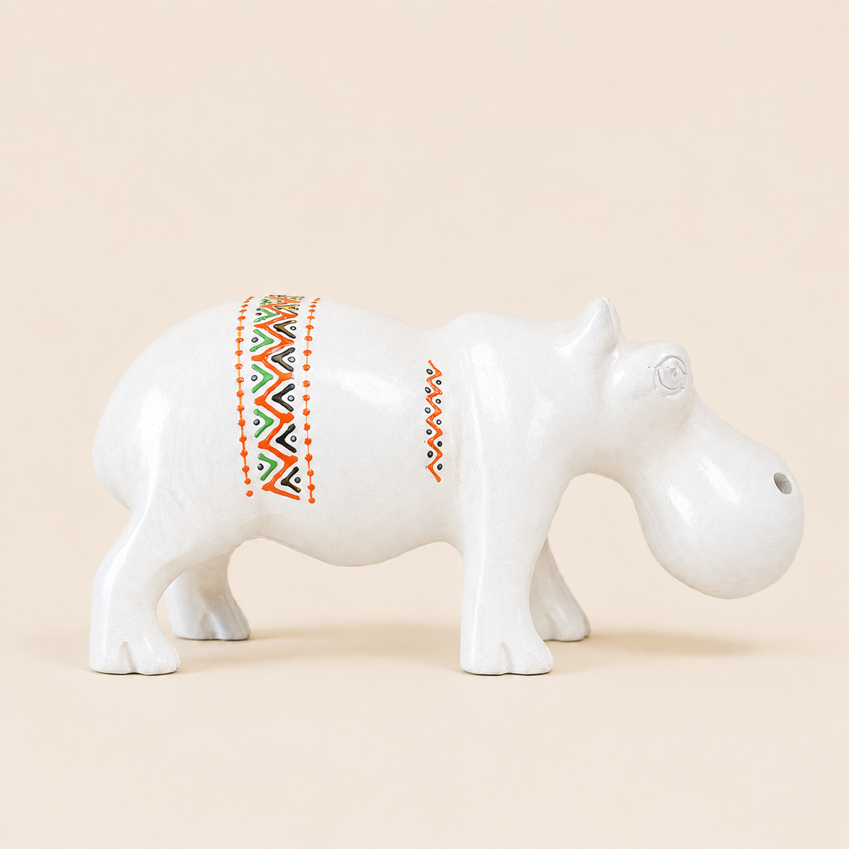 White hippo figurine with colorful pattern on a beige background
