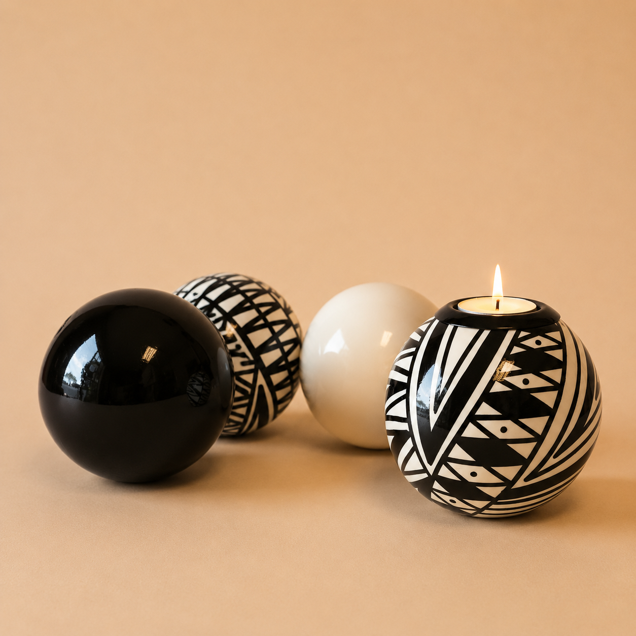 Three Monkey Balls in Mono colours if Black, white and mixed patterns with a Patterned Monkey Ball tlite on a beige background
