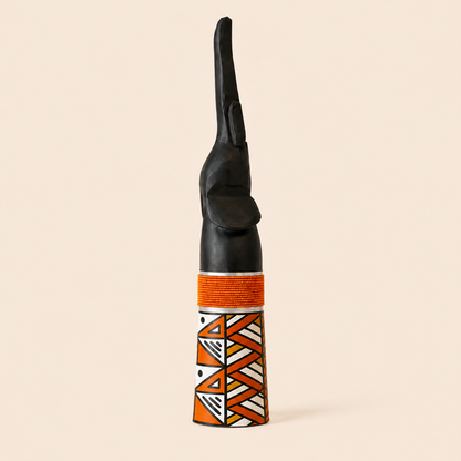Wood carved goodluck elephant with Orange beads and Ndebele patterns on a beige background