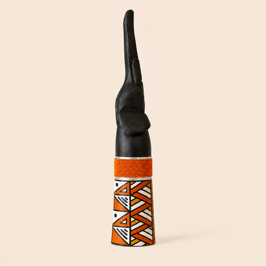 Wood carved goodluck elephant with Orange beads and Ndebele patterns on a beige background