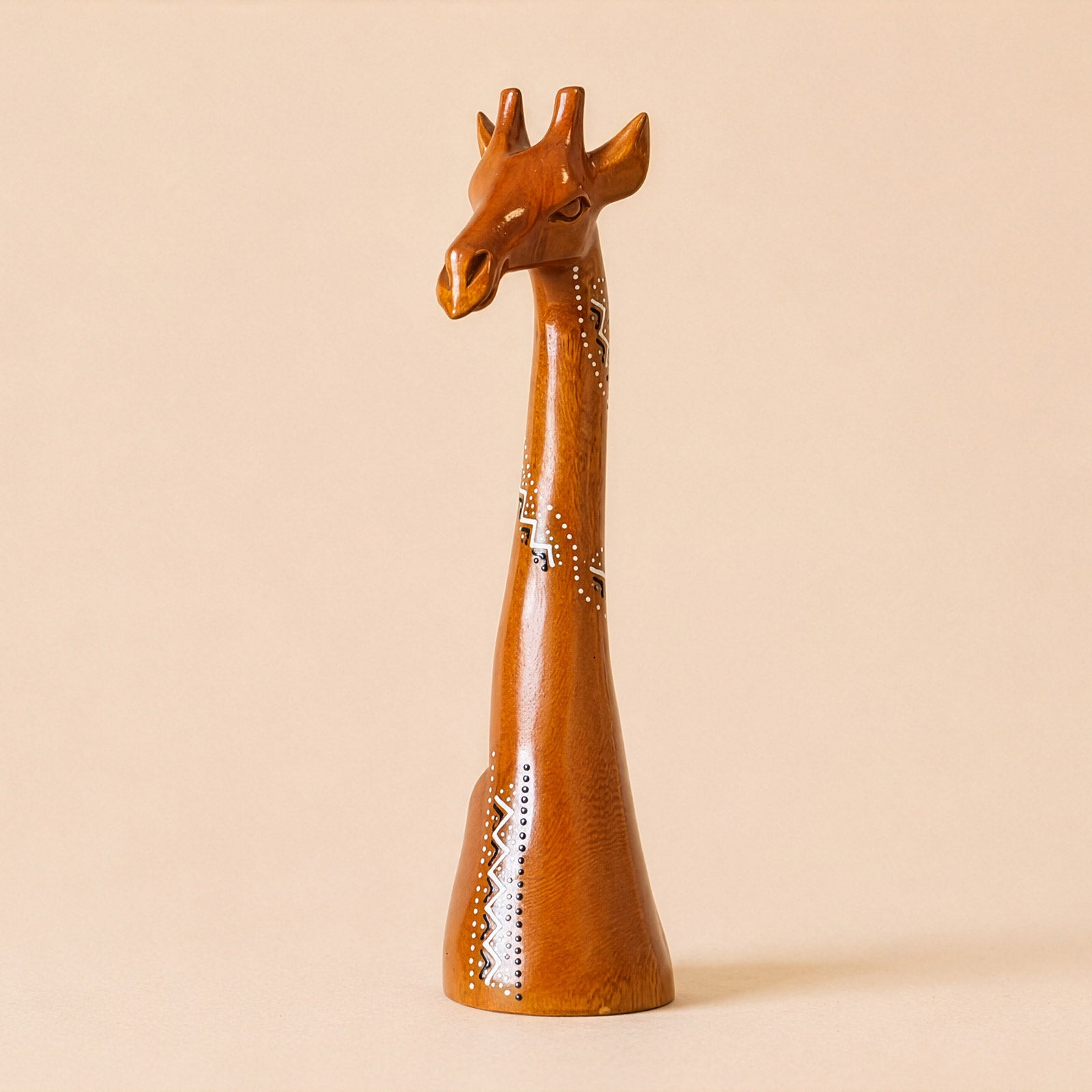 Wooden giraffe figurine on a beige background with ethnic patterns